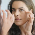 Beautiful Female Looking at Aging Skin in Mirror - Concierge Aesthetics Irvine